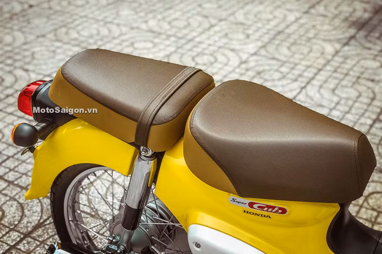 Chiếc xe vẫn giữ nguyên bộ yên đơn và giá đèo hàng giống như truyền thống của Super Cub nhưng được trang bị thêm yên mêm "sẹc tông" đi kèm. Bên dưới yên xe là logo Super Cub cách điệu được thiết kế mang hơi hướng cổ điển, đẹp mắt với mảng sơn đỏ trên nền mạ chrome.