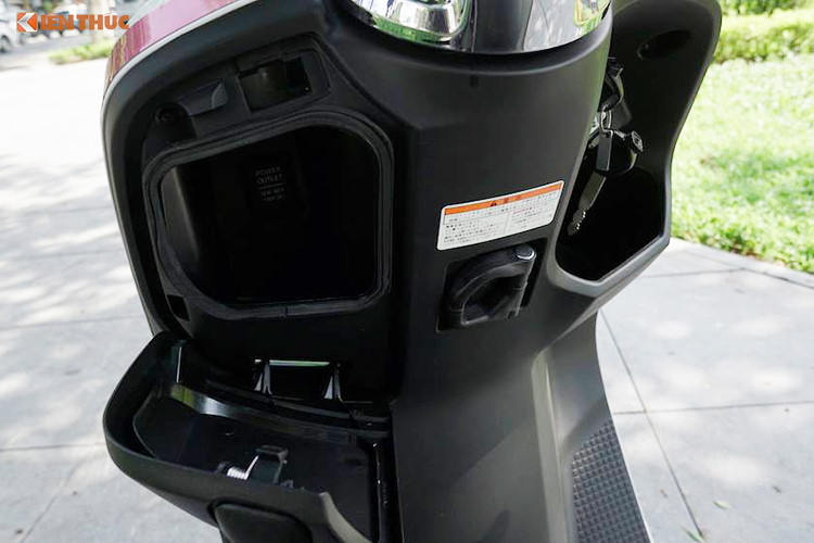 Phía trước chỗ ngồi của người lái là nơi đặt các hộc để đồ nhỏ. Hộc bên trái có hỗ trợ ổ sạc điện thoại 12V. Ở bên phải là nơi đặt ổ khóa (đáng tiếc nó không được trang bị chìa khoá smartkey), nút bấm mở yên và một hộc nhỏ để đồ phía dưới. Ở giữa cũng có một móc treo đồ dùng.