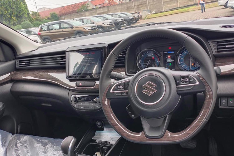 Nội thất xe Suzuki Ertiga Hybrid có một chút nâng cấp ở bảng đồng hồ thông tin để phù hợp với quy trình hiển thị thông tin hệ truyền động mild hybrid. Ngoài ra, không có sự khác biệt nào với các bản máy xăng, vẫn là ghế nỉ, vô-lăng bọc da, chi tiết ốp gỗ ở mặt táp-lô, màn hình giải trí 7 inch, đề nổ dạng nút bấm, điều hòa tự động...
