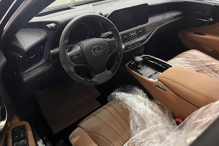 Khoang nội thất của Lexus LS 500 2022 sử dụng tông màu da bò chủ đạo, mang đến vẻ sang trọng và ấm cúng. Đáng chú ý, các ghế ngồi vẫn còn được bọc ni-lông, giữ nguyên độ căng và không có dấu hiệu xuống cấp. Tuy nhiên, do thời gian dài không sử dụng, vô-lăng có xuất hiện một số vết mốc nhẹ nhưng có thể dễ dàng xử lý bằng cách vệ sinh lại cabin.