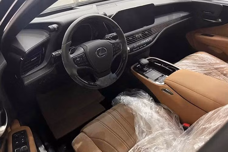 Khoang nội thất của Lexus LS 500 2022 sử dụng tông màu da bò chủ đạo, mang đến vẻ sang trọng và ấm cúng. Đáng chú ý, các ghế ngồi vẫn còn được bọc ni-lông, giữ nguyên độ căng và không có dấu hiệu xuống cấp. Tuy nhiên, do thời gian dài không sử dụng, vô-lăng có xuất hiện một số vết mốc nhẹ nhưng có thể dễ dàng xử lý bằng cách vệ sinh lại cabin.