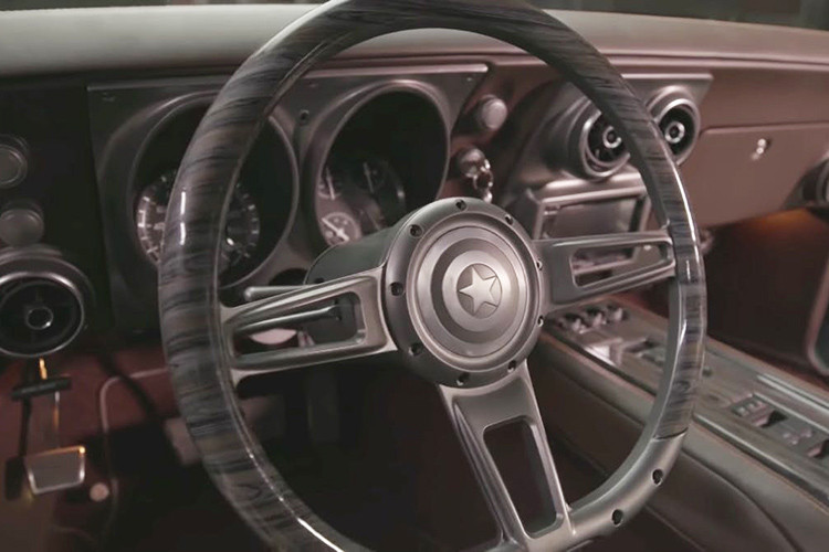 Trên vô lăng của chiếc "xe cơ bắp" Chevrolet Camaro này có biểu tượng hình chiếc khiên đặc trưng của Đội trưởng Mỹ. Trong khi đó, ở bậc cửa xuất hiện ốp ghi dòng chữ "Steve Rogers Special Edition".