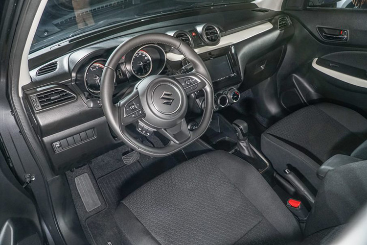 Đáng tiếc là Suzuki Swift mới lại trung thành với thiết kế “truyền thống” ốp nhựa cho táp-lô, viền cửa và bọc nỉ ghế ngồi. Vô-lăng trên phiên bản GL của Suzuki Swift 2018 được bọc Urethane, tích hợp nút chỉnh âm thanh trong khi đó bản GLX sẽ được bọc da, tích hợp nút điều khiển hành trình và thoại rảnh tay.