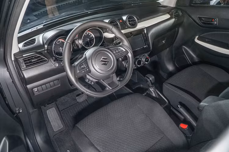 Đáng tiếc là Suzuki Swift mới lại trung thành với thiết kế “truyền thống” ốp nhựa cho táp-lô, viền cửa và bọc nỉ ghế ngồi. Vô-lăng trên phiên bản GL của Suzuki Swift 2018 được bọc Urethane, tích hợp nút chỉnh âm thanh trong khi đó bản GLX sẽ được bọc da, tích hợp nút điều khiển hành trình và thoại rảnh tay.