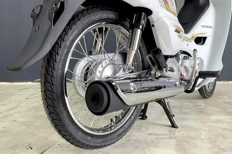 Honda Dream 125 2025 dùng phanh tang trống, phần ống xả có thêm ốp bảo vệ mạ chrome. Bên dưới yên xe có hộc chứa đồ, mở bằng chìa khóa cơ. Hệ thống treo kép đem lại hành trình thoải mái hơn. 