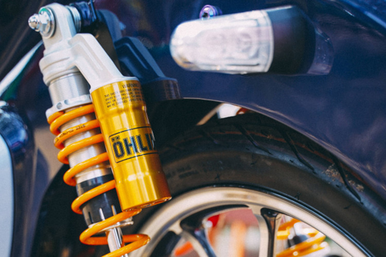 Phía sau là hệ thống giảm xóc Ohlins đi kèm bình dầu với lò xo vàng óng ánh đặc trưng của mẫu Ohlins cao cấp, đây là mẫu phuộc đồ chơi có ty phuộc &amp; lò xo lớn hơn zin, nó đáp ứng tốt độ nhún nảy hợp lí trong mọi địa hình, phía chân phuộc có núm chỉnh vặn ngược lại là nhanh, mềm hơn. Lúc đi tour chạy nhanh hơn thì vặn vô thêm vài nấc.