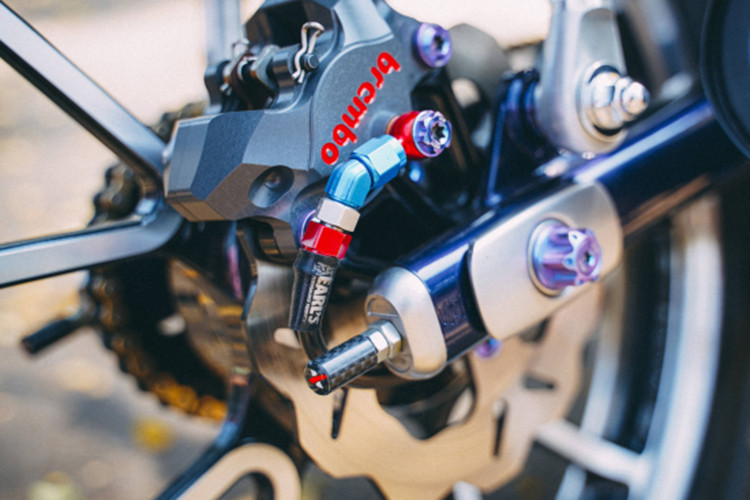 Để liên kết đĩa &amp; heo cố định hoàn chỉnh trên bánh lái trước bắt buôc phải gia công pas nhôm CNC chạy máy cho độ chính xác cực cao, pas được nhuộm đen để mang lại sự cứng cáp cho người nhìn. Bên cạnh đó là dây dầu Earl's UK nổi bật với gam màu đỏ, toàn bộ chi tiết ở bánh lái trước được cố định bằng ốc Proti cấu tạo từ Titanium.