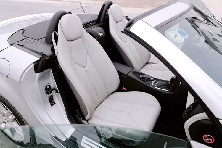 Ghế da vẫn khá căng và có chất lượng tốt dù đã ngả màu. Trang bị trên SLK 200 tương đối cơ bản. Phanh tay cơ, cả 2 ghế ngồi trên xe cũng đều là dạng chỉnh cơ. Các chi tiết nội thất xe mang phong cách thể thao, cá tính. 