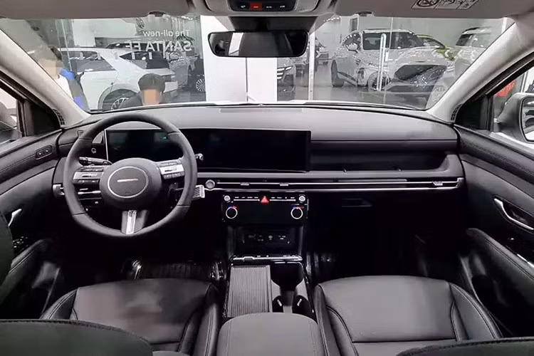 Bên trong khoang cabin của Hyundai Tucson 2025 được trang bị cụm màn hình kép giống như "đàn anh" Santa Fe 2024. Cụm màn hình này bao gồm đồng hồ lái điện tử và màn hình giải trí trung tâm có cùng kích thước 12,3 inch ghép lại với nhau. Vô lăng ba chấu được làm thanh mảnh hơn, tích hợp cụm phím bấm chức năng. 