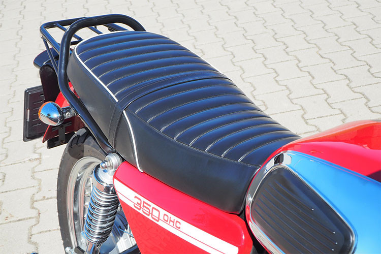 Từ bình xăng ốp mạ bóng kèm má cao su, những tấm chắn hai bên thân xe... tất cả đều được tái hiện trung thực "hình bóng" của mẫu xe Jawa 350 phân khối 2 kỳ nổi tiếng một thời. Yên xe dạng mềm thiết kế liền khá ấn tượng, hai bên thân xe được làm mới bằng logo 350 OHC.