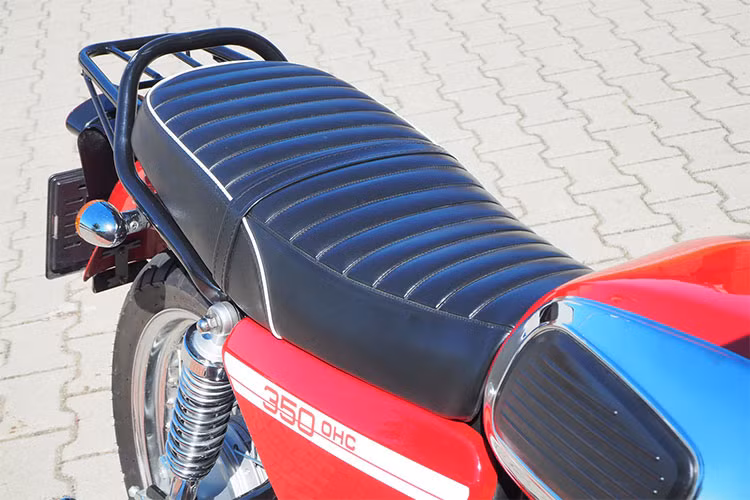 Từ bình xăng ốp mạ bóng kèm má cao su, những tấm chắn hai bên thân xe... tất cả đều được tái hiện trung thực "hình bóng" của mẫu xe Jawa 350 phân khối 2 kỳ nổi tiếng một thời. Yên xe dạng mềm thiết kế liền khá ấn tượng, hai bên thân xe được làm mới bằng logo 350 OHC.