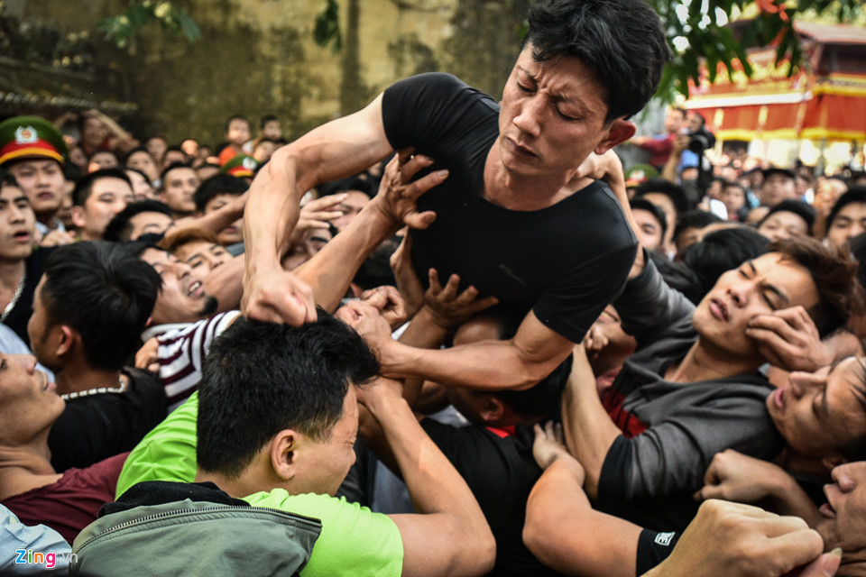 Màn cướp bông tại sân đình Sơn Đồng bắt đầu. Hàng trăm người chen lấn, giẫm đạp lên nhau trước sự chứng kiến của nhiều du khách. Trong ảnh là một thanh niên tung cú đấm vào đỉnh đầu đối phương.