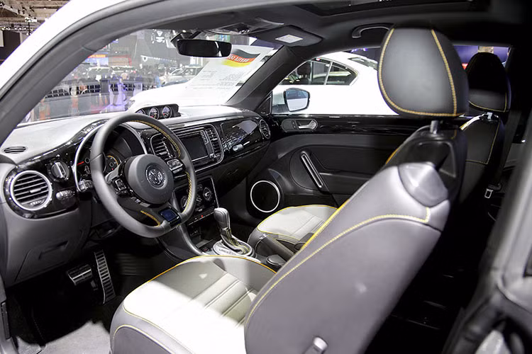 Nội thất Beetle Dune cá tính và thu hút, đặc biệt các chi tiết được thiết kế thời trang và đầy tính tiện ích như; vô-lăng 3 chấu bọc da, điều chỉnh đa hướng, tự động thu lại khi va đập, tích hợp các phím điều chỉnh đa chức năng, gương chiếu hậu bên trong tự động chóng chói, cụm đồng hồ điện tử Premium hiển thị đa thông tin, nút khởi động Start-Stop Engine,...