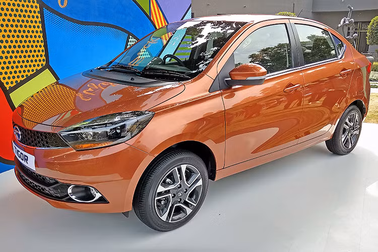 Tata Tigor sở hữu phần đầu không có gì nổi bật, thậm chí nếu nhìn kỹ bạn sẽ tưởng tượng ra một số chi tiết của dòng xe nổi tiếng nào đó trên Thế giới hiện any. Lưới tản nhiệt của xe được thiết kế dạng tổ ong với logo Tata chính giữa, trang bị phần đầu với đèn pha halogen và cụm đèn sương mù bên dưới.
