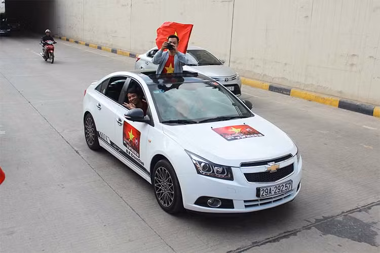 Một chiếc xe Chevrolet Cruze được trang trí cờ hoa và băng rôn cổ vũ cho đội tuyển U23 Việt Nam trước giờ bóng lăn chiều nay 23/1.