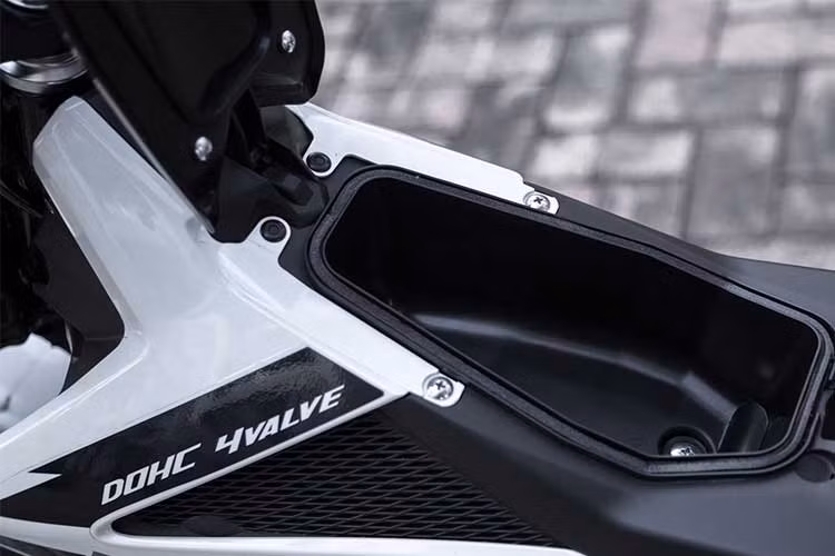 So với đối thủ là Honda Winner 150, chiếc Raider R150 Fi được hãng bổ sung thêm một hộc đựng đồ nhỏ ở phần thân xe khá thuận tiện. Phần tay lái thiết kế khá đơn giản với một nút bấm đề nổ bên phải cùng các nút phím đèn xin-nhan, đèn pha bên tay trái.