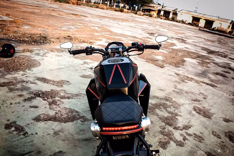 Cụm ghi đông xe được trang bị thêm cặp kiếng gù CRG Arrow đầy phong cách. Phần đuôi xe với yên mềm được khâu thủ công dạng mắt cáo bằng các đường chỉ đỏ, bên dưới cụm đèn hậu Led độ khiến cho dàn đuôi nhìn hiện đại hơn.