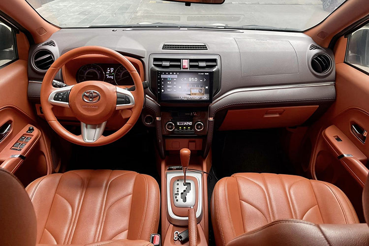 Bên trong, Toyota Rush 2019 sở hữu không gian nội thất được bố trí đơn giản nhưng thực dụng. Xe trang bị vô lăng 3 chấu đa chức năng, khởi động nút bấm Start/Stop và một màn hình giải trí cảm ứng đặt ở vị trí trung tâm, dễ thao tác. Cụm đồng hồ hiển thị lấy cảm hứng từ Fortuner với hai đồng hồ analog và một màn hình TFT chính giữa, cung cấp đầy đủ thông tin vận hành.