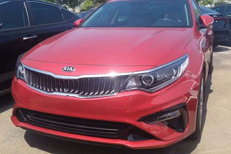 Mới đây, những hình ảnh của mẫu xe Kia Optima 2019 bản nâng cấp giữa vòng đời (facelift) tại Việt Nam đã tiếp tục được chia sẻ trên mạng. Những hình ảnh này chụp hàng loạt chiếc Kia Optima mới hiện đang nằm tại nơi được cho là kho của nhà máy. Như vậy, có thể dự đoán ngày ra mắt Việt Nam của mẫu sedan hạng D này đang đến rất gần.