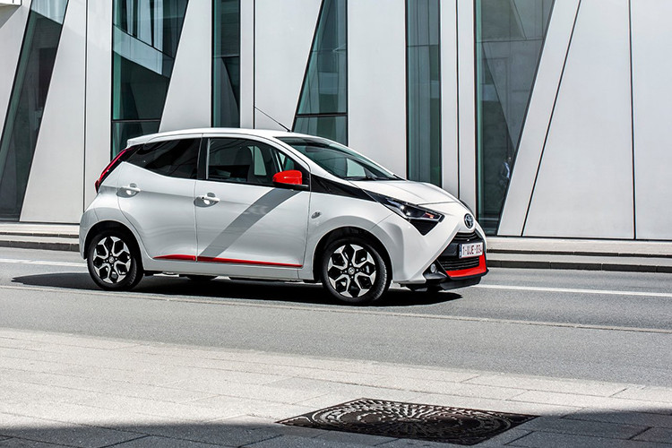 Toyota Aygo X-Trend 2019 được dán decal đỏ cho phần dưới cản trước, bậc cửa và cụm gương. phần đầu mới với chi tiết như khe gió nằm ngay bên dưới cụm đèn pha, đèn chiếu sáng projector và đèn ban ngày LED hiện đại được bố trí khéo léo ở gần khu vực đèn sương mù.