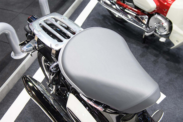 Yên xe không thể nhầm lẫn của dòng Super Cub vẫn giữ nguyên phong cách, phía sau là giá đèo hàng hoặc tuỳ biến cho việc chở thêm người...