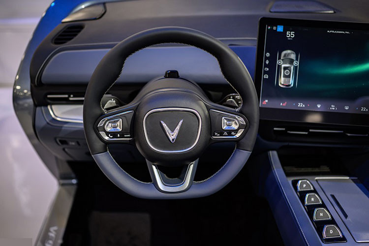 Vô-lăng của Vinfast VF9 tạo hình chữ nhật bo tròn bốn góc cá tính, tích hợp các phím chức năng hỗ trợ lái tiện lợi. Thiết kế này khá sát với bản concept trước đó. Cần số dạng nút bấm thời thượng.