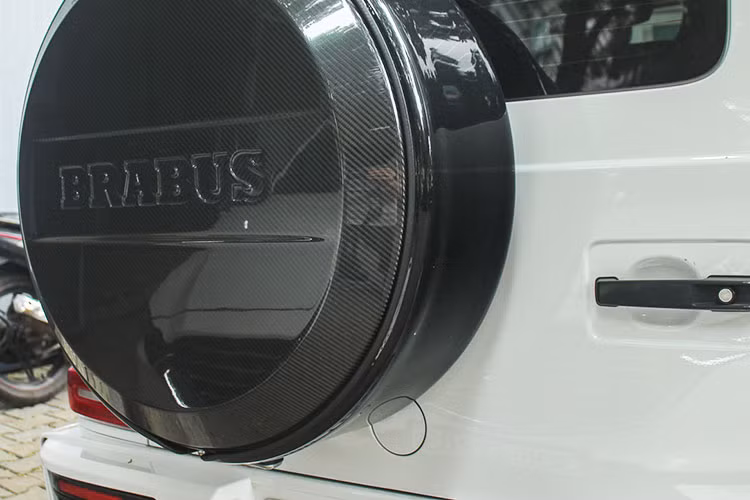 Lưới tản nhiệt gồm các nan ngang trên Mercedes-Benz G350d nay được thay thế bằng các nan dọc sơn đen như Mercedes-AMG G63, chính giữa là logo Brabus nền đen chữ đỏ nổi bật. Xe vẫn được trang bị cụm đèn LED Multibeam quen thuộc của dòng G-Class. Nắp capo nguyên bản được nâng cấp cơ bắp hơn nhờ phần nắp bên trên bằng sợi carbon của Brabus.