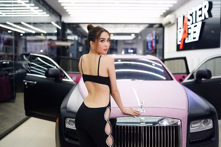 Chiếc xe siêu sang Rolls-Royce Ghost của Ngọc Trinh khoe ảnh có ngoại thất dán nửa thân trên màu hồng cùng kim tuyến và hơn nửa thân dưới của xe có màu đen nhám được khoác áo mới bằng đề-can.
