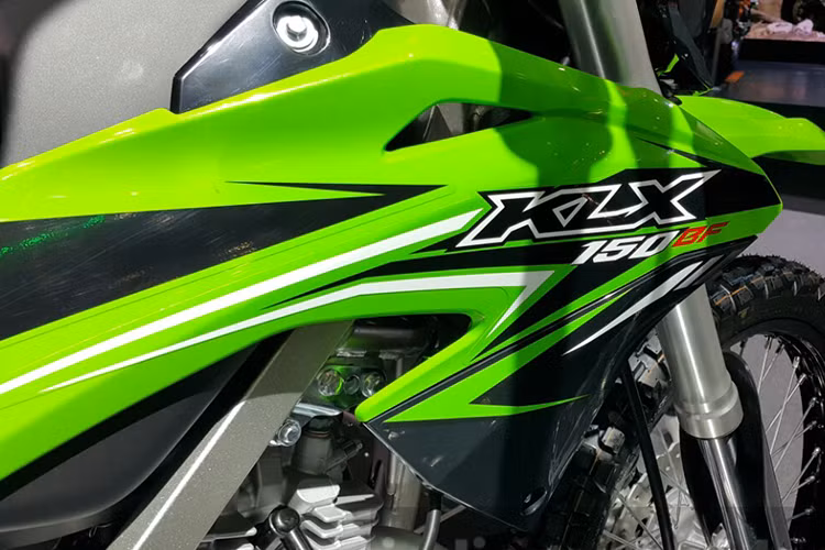 Trên mẫu xe cào cào cỡ nhỏ này, không chỉ bề rộng thân xe mà khá nhiều chi tiết trên mẫu phiên bản Kawasaki KLX 150 đều được thu gọn để thuận tiện luồn lách qua những địa hình khó như phượt băng suốt đường rừng. Phần yên xe, các tấm ốp nhựa thân xe, hệ thống ống xả khí, mặt nạ chóa đèn pha, cụm đèn xi-nhan... đều được thiết kế gọn gàng.