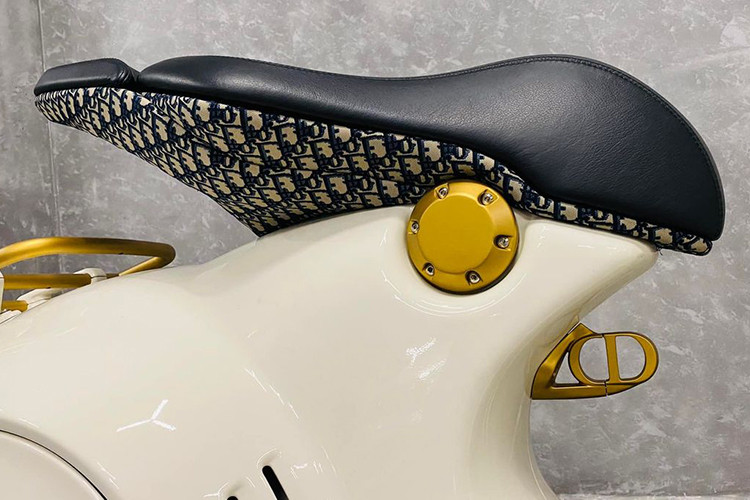 Điểm khác biệt dễ dàng nhận thấy nhất và cũng ấn tượng nhất trên Vespa 946 Christian Dior đến từ màu sơn và các phụ kiện đi kèm. Chiếc xe được khoác trên mình lớp “áo” màu trắng nhẹ nhàng kết hợp với các điểm nhấn màu vàng đồng và họa tiết trang trí đặc trưng của thương hiệu thời trang Pháp.
