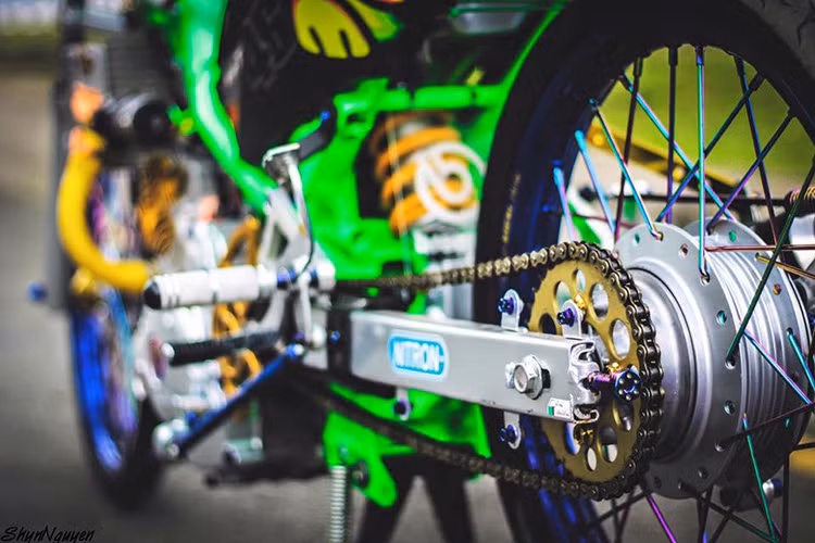 Gắp nhôm sau sử dụng N.S.D vàng cùng hàng loạt ốc hàng hiệu và vành sau 7 màu sử dụng lốp căm nổi bật.