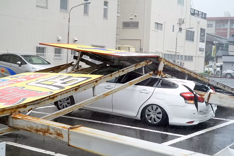 Những tấm pa nô, áp phích đè nát một chiếc sedan tại bãi đỗ.