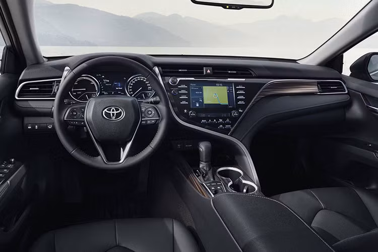 Nội thất của mẫu xe Camry Hybrid 2019 gây ấn tượng bởi vô-lăng 3 chấu tích hợp các nút chơi nhạc và bảng đồng hồ kích thước 7 inch được thiết kế lạ mắt. Nội thất của xe còn được bổ sung vật liệu gỗ cao cấp và màn hình hiển thị trên kính chắn gió HUD lên đến 10 inch.