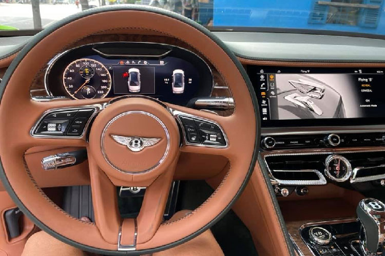 Không gian nội thất của Flying Spur V8 First Edition mới thể hiện đẳng cấp của Bentley với vẻ đẹp hiện đại, tinh tế và sang trọng. Điểm nhấn là màn hình cảm ứng trung tâm 12,3 inch có thể xoay hiển thị cụm 3 đồng hồ thể hiện thông tin về nhiệt độ bên ngoài, la bàn và chronometer, hoặc ẩn dưới lớp veneer bóng loáng.
