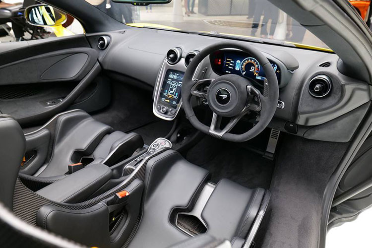 Nội thất siêu xe McLaren 600LT Spider ở Hồng Kông bao trùm với tông màu đen ở chất liệu da bọc khoang lái cho đến các chi tiết bằng sợi carbon bóng. Điểm nhấn phải kể đến dây đai an toàn màu vàng Sicilian Yellow "tông xuyệt tông" với màu sơn ngoại thất.