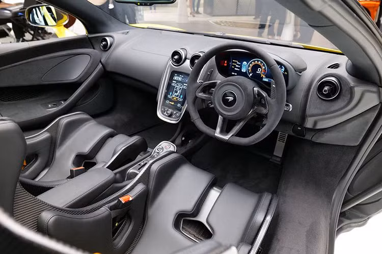 Nội thất siêu xe McLaren 600LT Spider ở Hồng Kông bao trùm với tông màu đen ở chất liệu da bọc khoang lái cho đến các chi tiết bằng sợi carbon bóng. Điểm nhấn phải kể đến dây đai an toàn màu vàng Sicilian Yellow "tông xuyệt tông" với màu sơn ngoại thất.