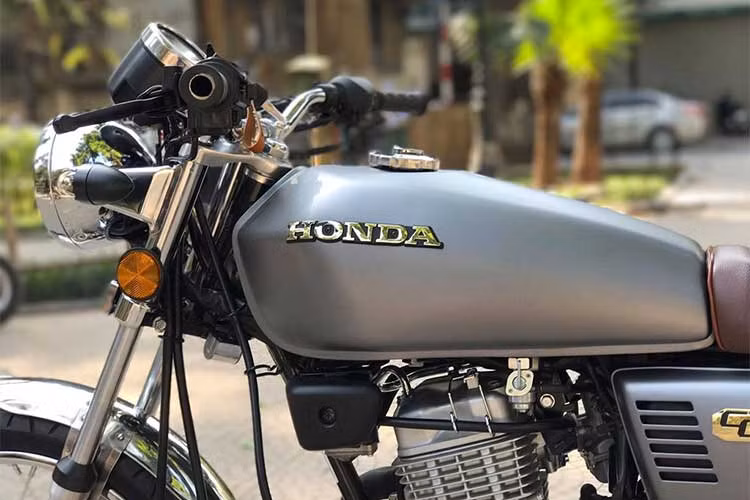 Bình xăng giữ nguyên bản nhưng đã lột bỏ hết tem cũ và sơn lại màu chì. Vè chắn bùn trước của xe cũng đã được thu gọn lại khiến cụm bánh trước trống trải và phong trần đúng chất bụi của tracker.