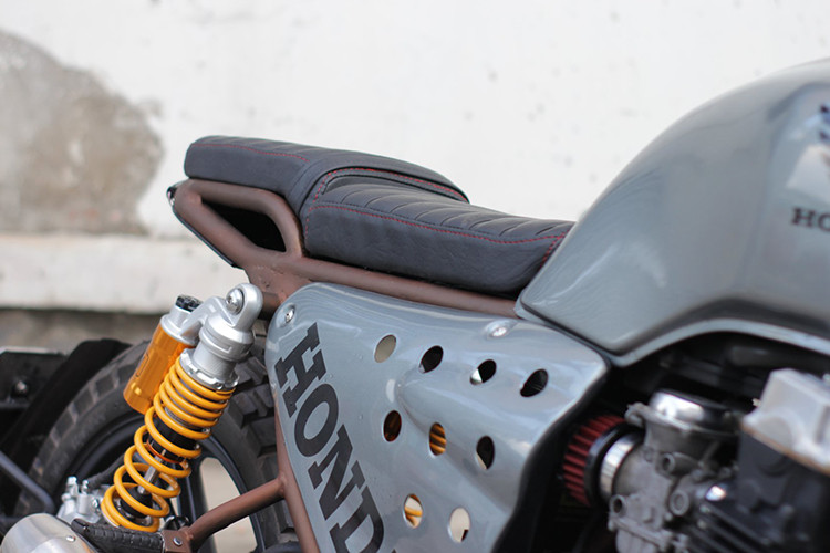 Bộ yên của xe được làm thủ công với các đường vân chần chỉ khá đẹp mắt, phần đuôi với chắn bùn rời hạ thấp. Ở phía sau chiếc xe, người thợ độ tài hoa cũng khéo léo tích hợp một đèn hậu LED dưới gầm. Ngoài ra việc thiết kế tấm ốp hai bên với logo Honda cỡ lớn cũng làm tăng thêm sức hút cho xe.