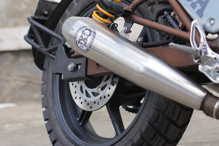 Trên bản độ này, dàn chân của xe đã được Tự Thanh Đa làm mới lại. Đáng chú ý chính là cặp phuộc sau đến từ thương hiệu Ohlins màu vàng, kết hợp cùng bộ khung sườn lộ diện hoàn toàn mang lại cảm giác khá lạ mắt. Đáng chú ý cặp ống xả cũng được thay mới cho tiếng nổ ấn tượng.