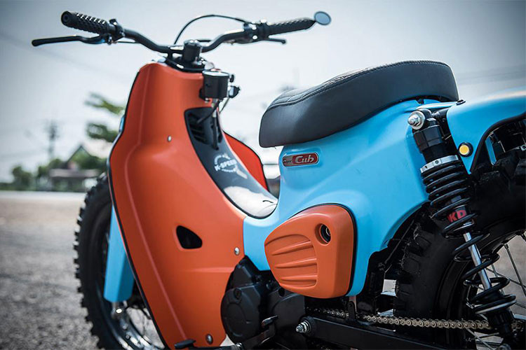 Ở dàn chân sau, cặp phuộc ngắn và yếu ớt của chiếc xe máy Honda Super Cub "huyền thoại" đã được thay thế bằng phuộc lò xo OKD giúp đuôi xe được đẩy lên cao hơn và cho cảm giác lái tốt hơn cùng tay lái Tracker cho dáng lái thẳng tăng độ phấn khích khi điều khiển xe.