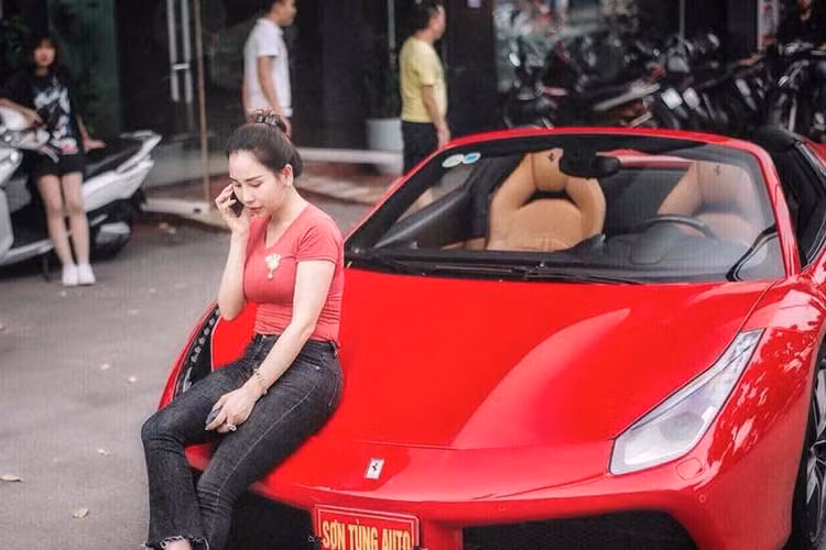 Trong bức ảnh "ngã sấp mặt" bên siêu xe mui trần Ferrari 488, có thể thấy bà chủ showroom xe sang tại Hà Nội còn "trang trí" thêm các cọc tiền với mệnh giá lớn khiến không ít người cảm thấy sốc. Ngoài ra, dưới mặt đường còn có đến 2 vỏ bọc điện thoại Vertu đắt tiền không kém.