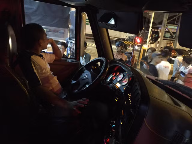 Một tài xế cố thủ trên xe container đậu choán hết làn thu phí trong khoảng 15 phút khiến giao thông ùn ứ - Ảnh: Mậu Trường