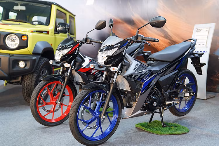 Về cơ bản, phiên bản Suzuki Satria F150 2025 tại Việt Nam chỉ đơn thuần là bản cập nhật màu sắc mới dành cho mẫu côn tay này. Cụ thể, sản phẩm sẽ có 3 lựa chọn màu sắc gồm trắng - đen đi kèm vành màu cam, đen đi kèm vành màu đỏ và xám - đen đi kèm vành màu xanh.