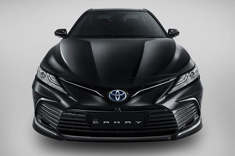 Tương tự bản Mỹ và châu Âu, Toyota Camry Hybrid 2022 tại Indonesia cũng được bổ sung thiết kế đầu xe mới với hốc gió trung tâm cỡ lớn, tách biệt rõ ràng hơn với cản trước. Hốc gió này đi kèm nan nằm ngang màu đen hoặc xám, kéo dài sang hai bên. Bao quanh hốc gió trung tâm này là đường viền hình chữ C dày dặn và có màu tối. Ngoài ra, nằm hai bên hốc gió trung tâm còn có cặp đèn sương mù trước khá nhỏ.