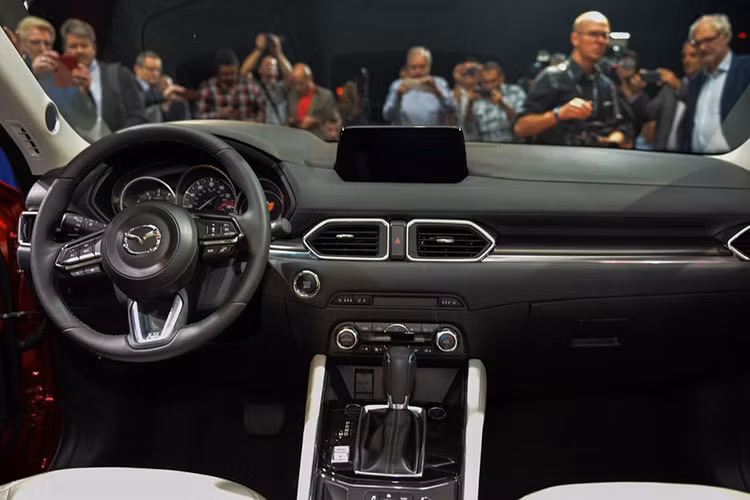 Bên trong nội thất, CX-5 mới đem lại cảm giác thoáng đãng và hiện đại hơn nhờ bảng táp-lô hoàn toàn mới, được tách rời thành 3 khu vực riêng theo bề ngang là các nút điều khiển trung tâm, khe gió và mặt trên. Nằm phía trên cùng của bảng táp-lô là hệ thống thông tin giải trí Mazda Connect với màn hình 7 inch kèm dàn âm thanh 10 loa Bose cao cấp.