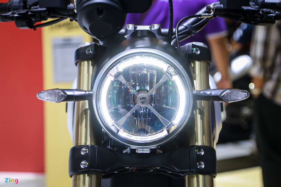 Điểm khác biệt đầu tiên so với các dòng Scrambler khác là biến thể 1100 có đèn pha tròn Full LED, bên trong có chữ "X". Đèn xi-nhan gọn gàng hơn.