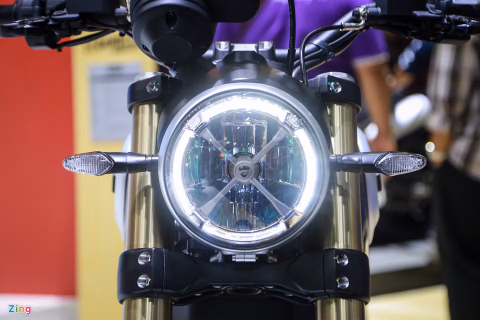 Điểm khác biệt đầu tiên so với các dòng Scrambler khác là biến thể 1100 có đèn pha tròn Full LED, bên trong có chữ "X". Đèn xi-nhan gọn gàng hơn.