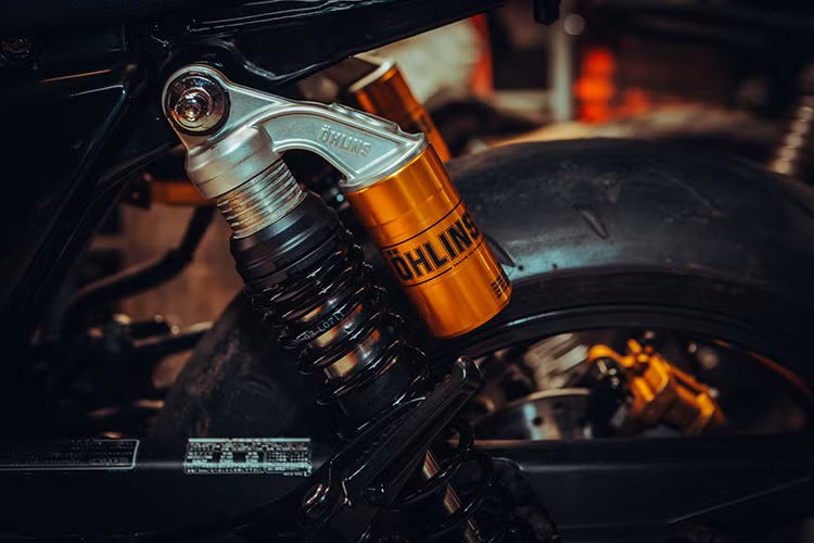 Nhìn từ phía sau, phần đuôi xe đã được cắt ngắn. Những chi tiết dè sau, đèn hậu, đèn xin nhan nguyên bản được người thợ khéo léo thay thế bằng cụm đèn “đồ chơi” gắn vào trong khuôn sườn, tích hợp đầy đủ đèn hậu, đèn xi nhan. Bên cạnh đó, các chi tiết như phuộc trước của xe thay thế bằng phuộc Up Side Down thương hiệu showa của chiếc Suzuki GSX, phuộc sau Ohlins phụ tùng chuyên biệt cho CB400SF.