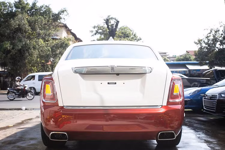 Cụ thể, ngoài bộ áo đỏ nổi bật, chiếc xe siêu sang Rolls-Royce Phantom thế hệ thứ 8 tại Campuchia còn có nắp capô, trần xe và nắp cốp đuôi sau hoàn thành với màu trắng sữa đẹp mắt và khi kết hợp với màu sơn đỏ tạo nên ngoại hình bắt mắt cho xe.