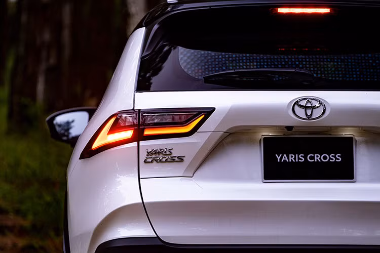 Đuôi xe tiếp tục thể hiện rõ chất nam tính với những nếp gấp in hằn hình thang tại khu vực biển số. Cản sau thiết kế dày dặn kết hợp với ốp màu đen. Đi kèm cụm đèn hậu nối thông với nhau bằng thanh kim loại chứa logo Toyota. Nhìn chung, Toyota Yaris Cross có vẻ như nhiều nét khá tương đồng với dòng SUV đang rất hot tại Việt Nam là Corolla Cross, cộng thêm âm hưởng từ RAV4. 